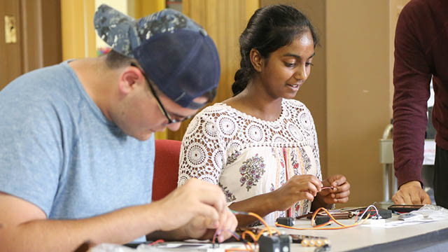Boy and girl working on engineering project with wires