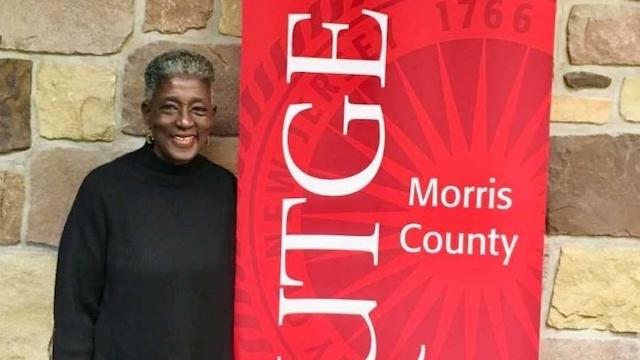 headshot of denise with rutgers morris county sign