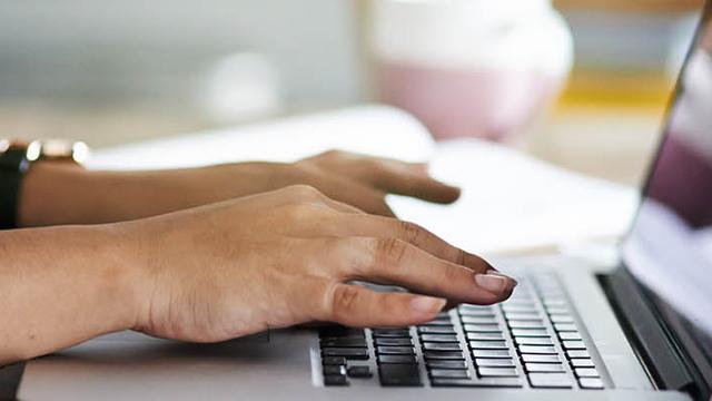 hands typing on laptop