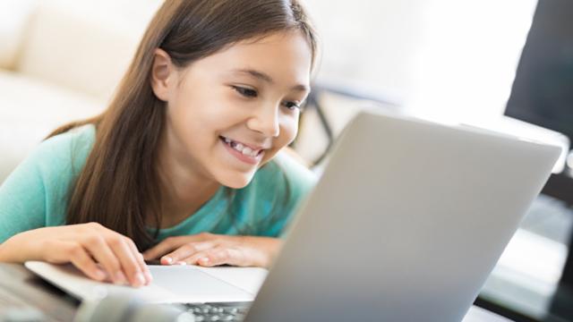 child smiling at laptop